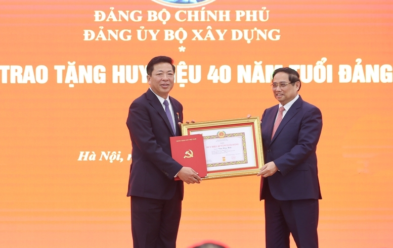 Thay mặt lãnh đạo Đảng, Nhà nước, Thủ tướng Chính phủ Phạm Minh Chính trao tặng Huy hiệu 40 năm tuổi Đảng cho Bộ trưởng Bộ Xây dựng Trần Hồng Minh - Ảnh: VGP/Nhật Bắc
