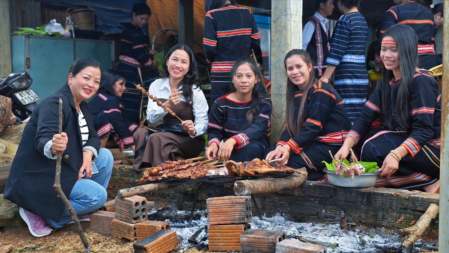 Mọi người quây quần, thường thức ẩm thực truyền thống của đồng bào Gia Rai như cơm lam, gà nướng...