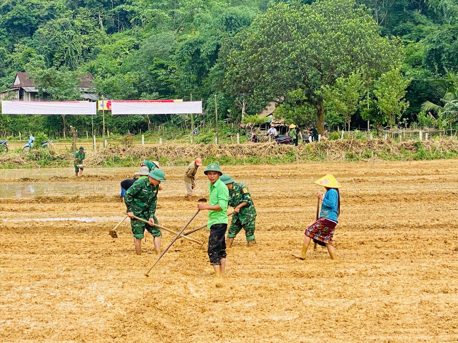 Cán bộ, chiến sĩ Tổ Biên phòng Rào Tre giúp đồng bào làm đất chuẩn bị gieo cấy lúa nước vụ đông xuân. Ảnh: Phạm Tiến
