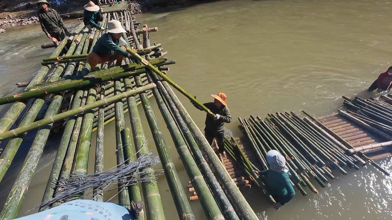 Người dân bản Chung Sơn chung tay dựng cầu tạm bắc qua sông Luồng, giúp việc đi lại an toàn hơn.