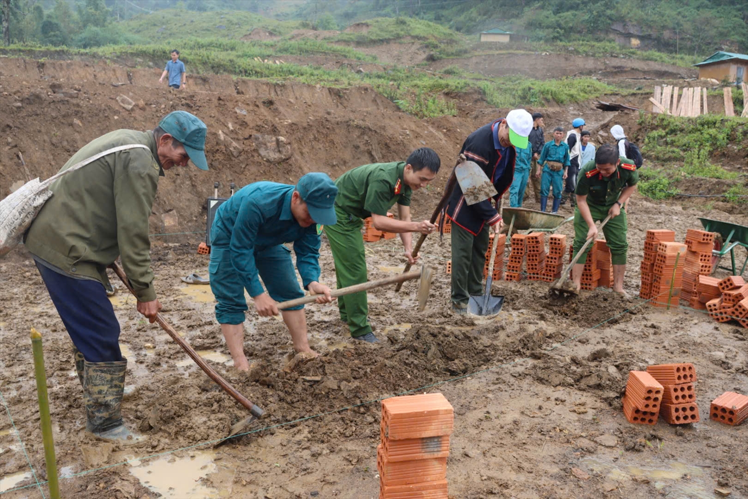 Cán bộ, công an, dân quân xã Măng Ri chung tay giúp đồng bào DTTS xây dựng nhà mới sau thiên tai. (Ảnh: Ngọc Chí)