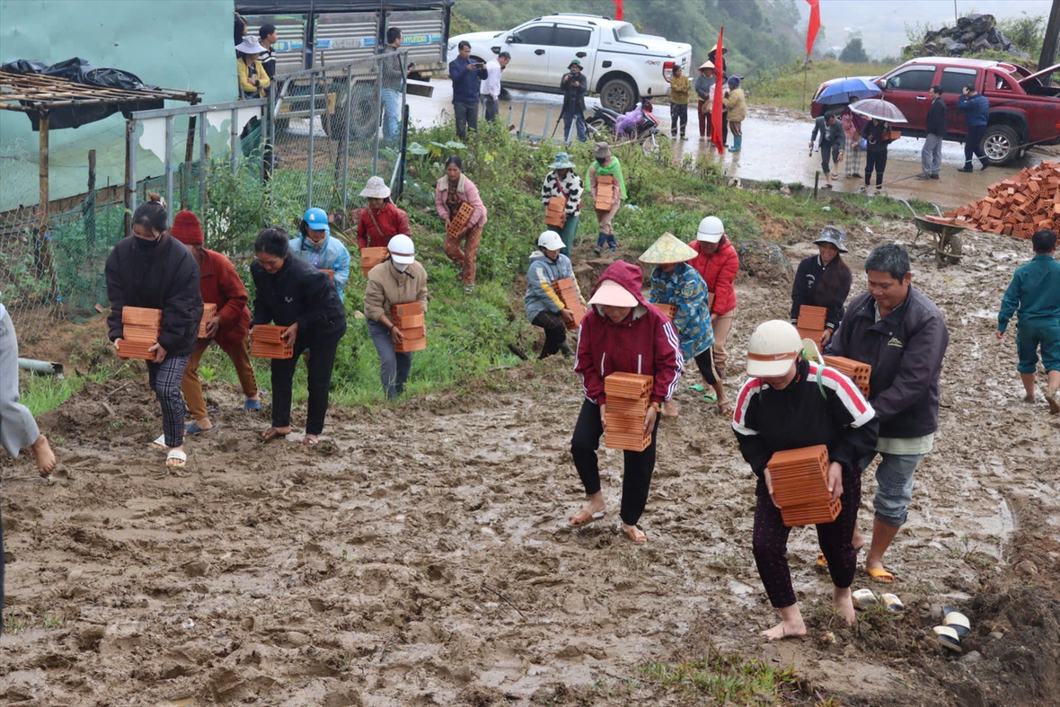 Đông đảo người dân tham gia vận chuyển gạch giúp các hộ có nhà bị thiệt do mưa bão xây dựng lại nhà mới. (Ảnh: Ngọc Chí)