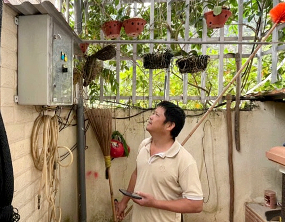 Anh Nguyễn Văn Dũng, với chiếc điện thoại thông minh đang kiểm tra hệ thống tưới tự động