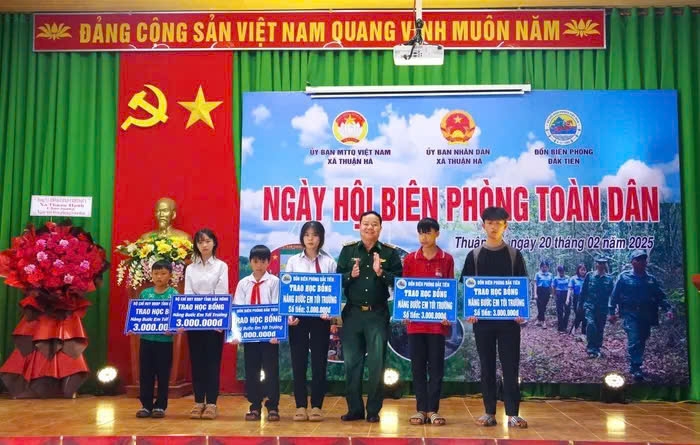 Đại diện lãnh đạo Bộ Chỉ huy BĐBP Đắk Nông tặng học bổng cho các em học sinh có hoàn cảnh khó khăn trong Chương trình “Nâng bước em tới trường - Con nuôi đồn biên phòng"" tại "Ngày hội Biên phòng toàn dân". Ảnh: TL