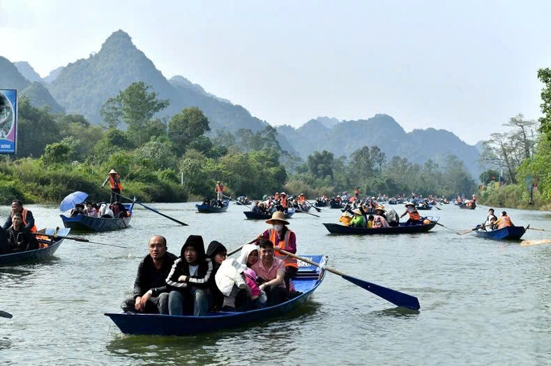 Du khách và người dân địa phương đi xuồng đò trên suối Yến vào trẩy hội chùa Hương