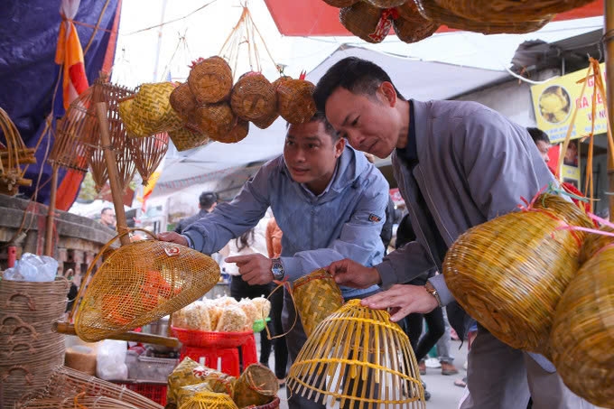 Du khách thăm quan, lựa chọn mua những kỷ vật nghề nông để lấy may mắn khi đi chợ Viềng. Ảnh: TL