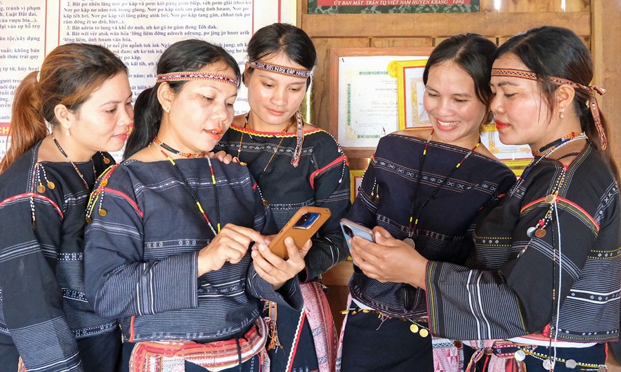 Các thành viên đội chiêng nữ Ba Na làng Kgiang (huyện Kbang) xem lại phần trình diễn được ghi hình bằng điện thoại