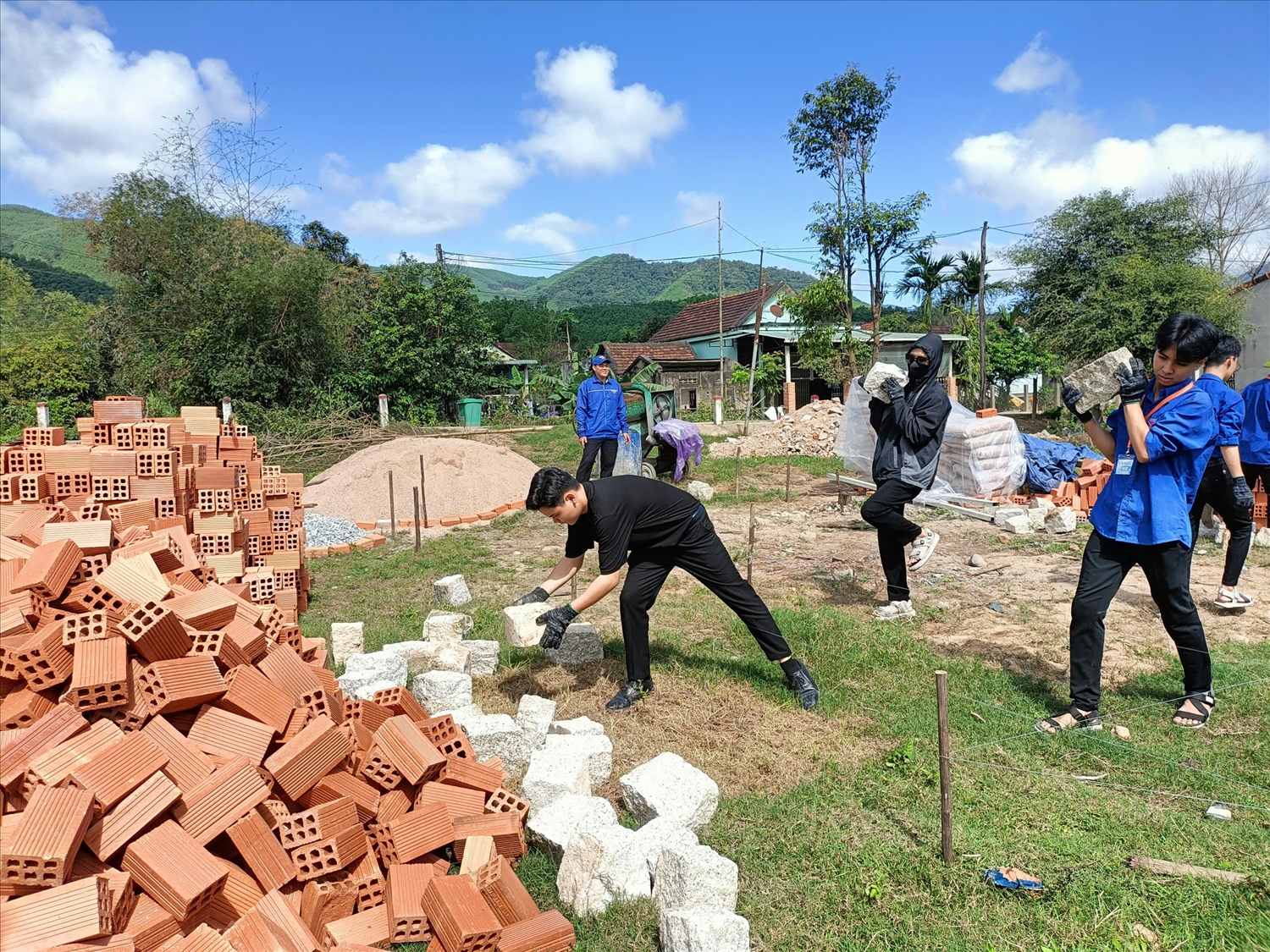 Thanh niên hỗ trợ người dân xây dựng nhà mới.