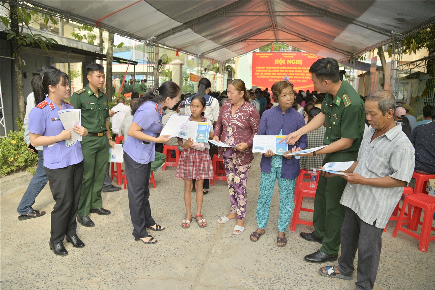 Cán bộ Biên phòng, Viện Kiểm sát hướng dẩn người dân tìm hiểu các nội dung trong tờ rơi về chống khai thác hải sản bất hợp pháp và các hành vi được xem là vi phạm pháp luật