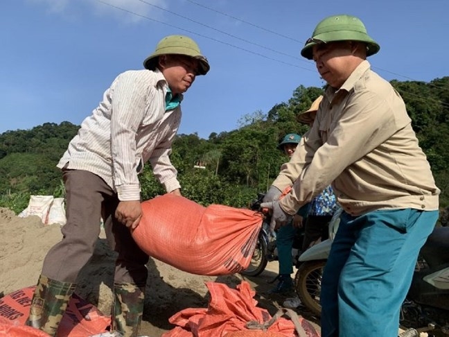 Cán bộ công chức xã Mỹ Thanh, huyện Bạch Thông, tỉnh Bắc Kạn vận chuyển vật liệu xây dựng hỗ trợ người dân xây dựng nhà ở (Ảnh: Nguyễn Thương).