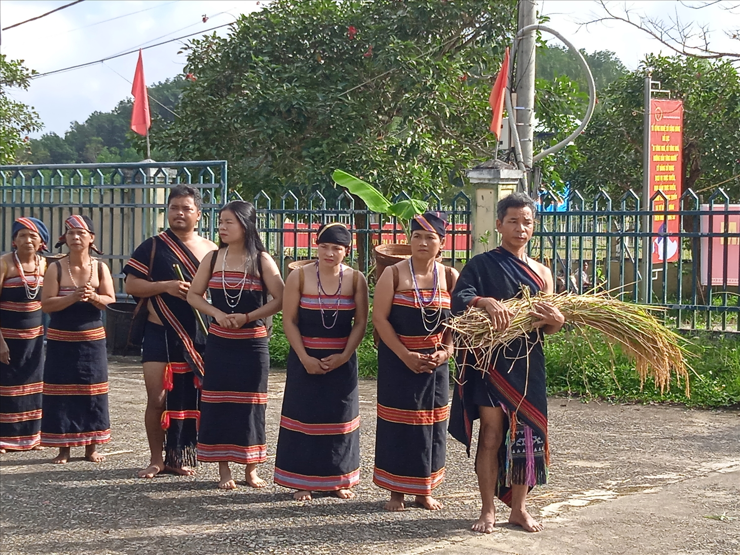 Ông Zơ Râm Diên (người đầu tiên cầm bó lúa) cùng dân làng trong phục dựng Lễ ăn mừng lúa mới của người Tà Riềng, xã Đắc Tôi tháng 8/2023.