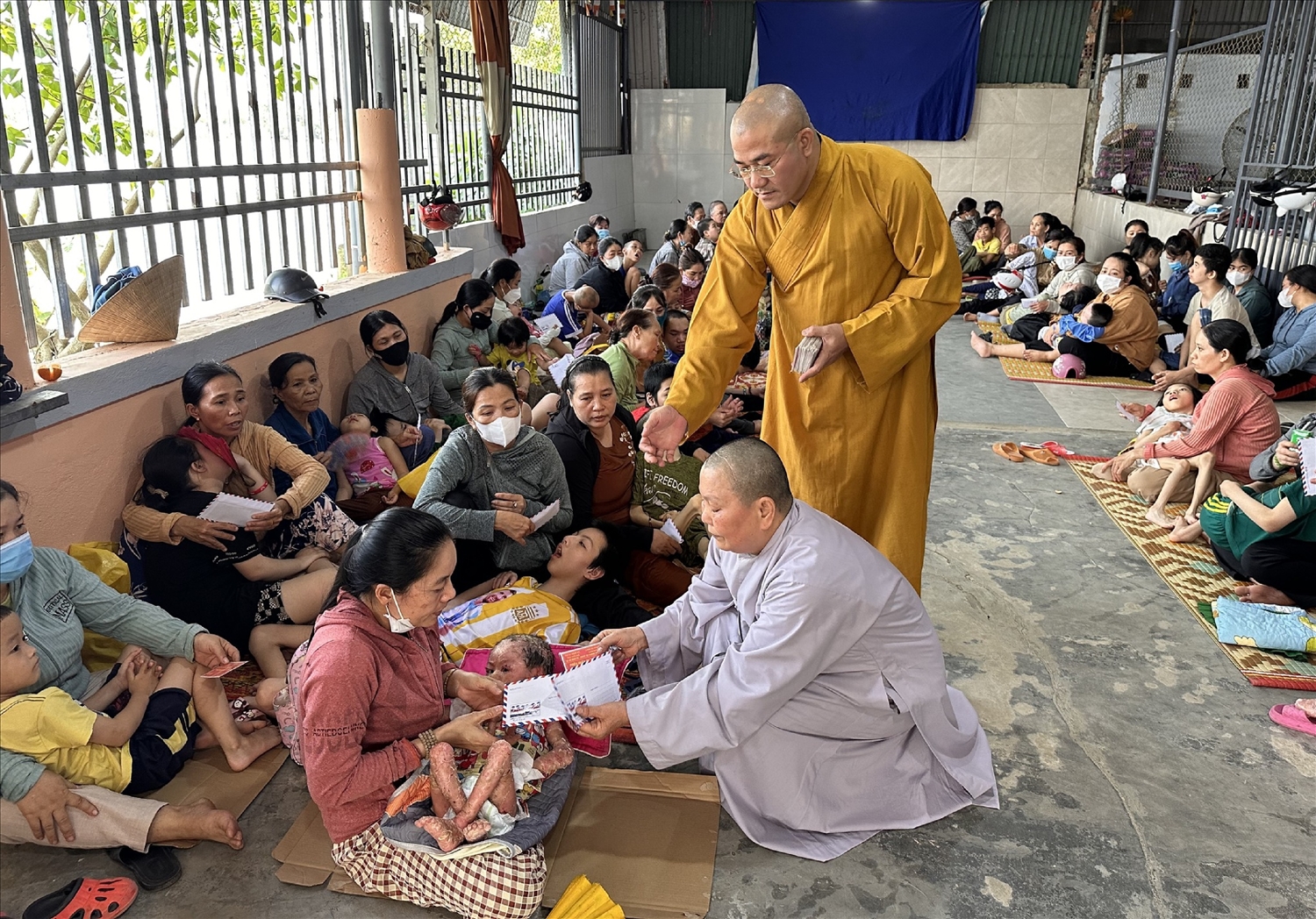 Đại đức Thích Tâm Phương (áo vàng) và Ni sư Thích Nữ Diệu Trung, nguyên Phó Trưởng Ban Trị sự GHPGVN huyện A Lưới đến thăm và tặng quà cho các cháu khuyết tật, chất độc màu da cam tại phường Hương Vinh, TP Huế.