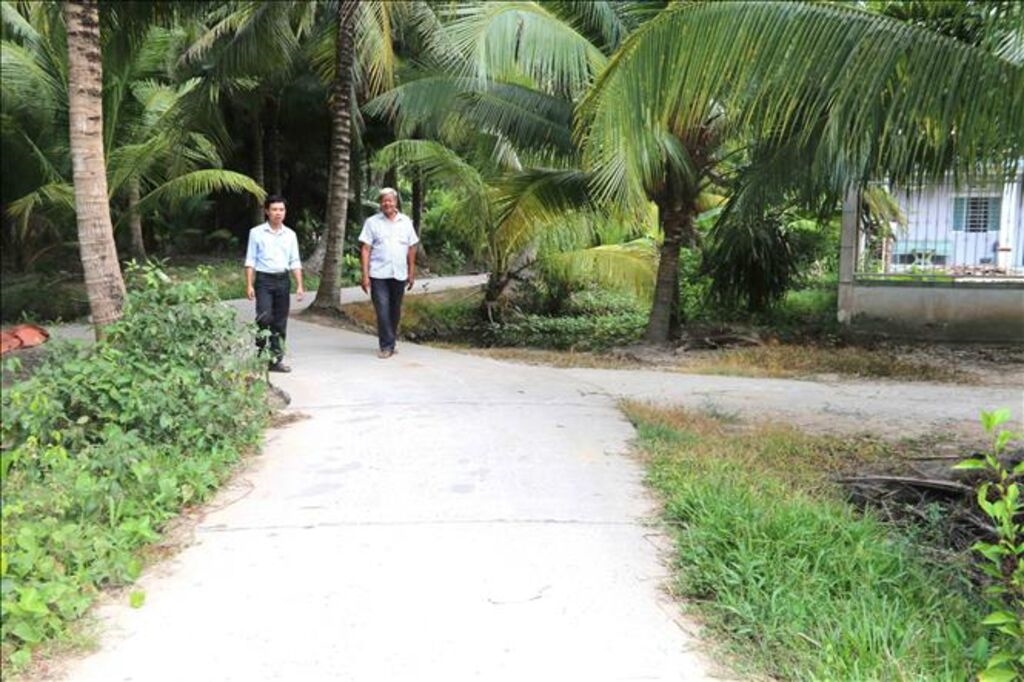 Đường đi do ông Kim Ruône (bên phải) Bí thư Chi bộ, Người có uy tín ấp Bót Chếch, xã Lương Hòa, huyện Châu Thành, tỉnh Trà Vinh hiến đất xây dựng. (Ảnh: Thanh Hòa).