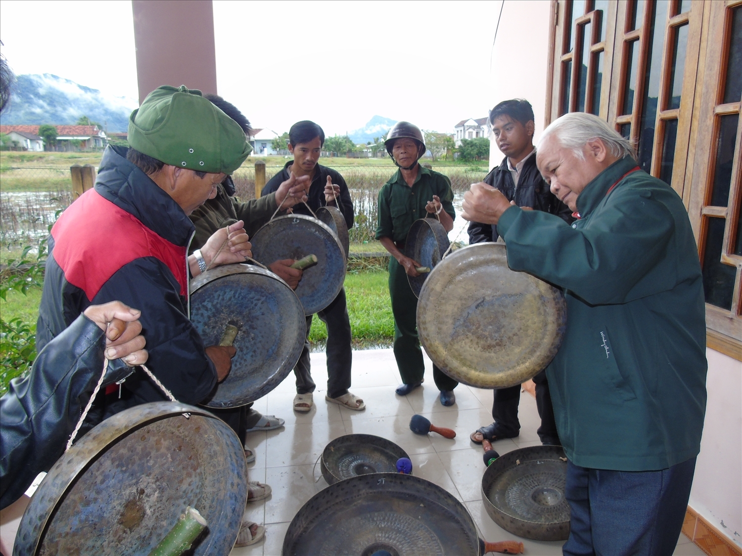 Nghệ nhân Ưu tú Yang Danh chỉ dạy cách đánh cồng chiêng cho đồng bào