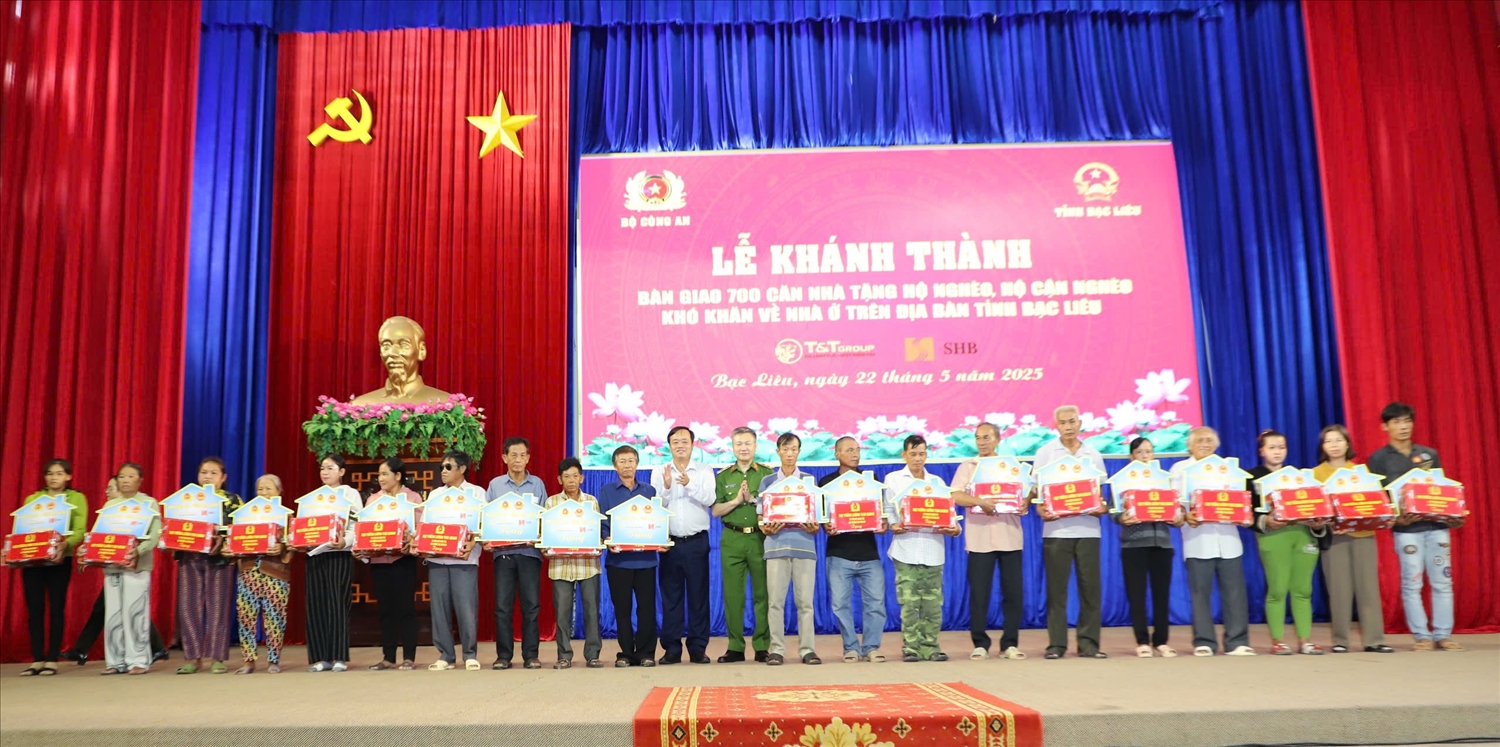 Thứ trưởng Nguyễn Ngọc Lâm và đồng chí Huỳnh Quốc Việt, Phó Bí thư Thường trực Tỉnh ủy Bạc Liêu trao bảng tượng trưng và quà mừng nhà mới 