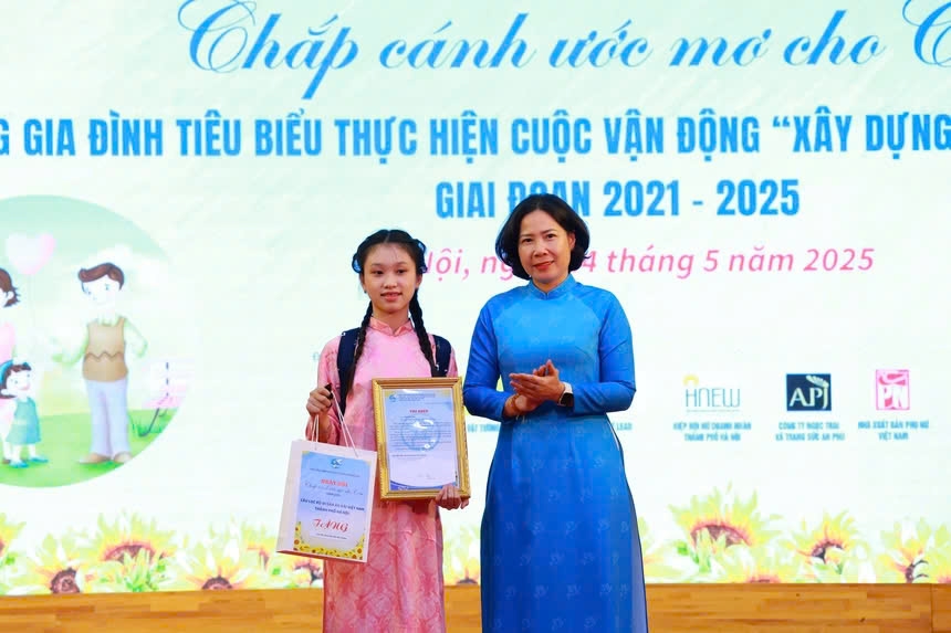 Chủ tịch Hội LHPN TP Hà Nội Lê Kim Anh (bên phải) trao học bổng cho em Bùi Gia Linh - học sinh Học viện Múa Việt Nam, con đỡ đầu của một thành viên của Hiệp hội Nữ doanh nhân Hà Nội
