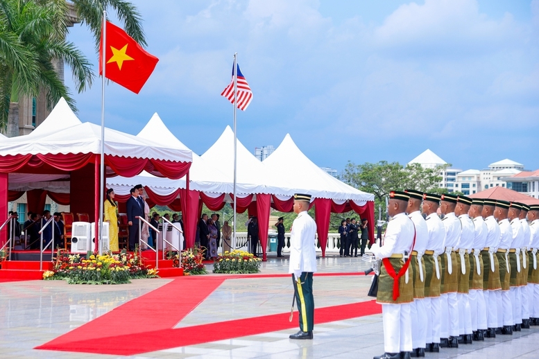 Khi hai Thủ tướng và hai Phu nhân đứng vào vị trí danh dự, dưới quốc kỳ hai nước, quân nhạc cử quốc thiều hai nước - Ảnh: VGP/Nhật Bắc