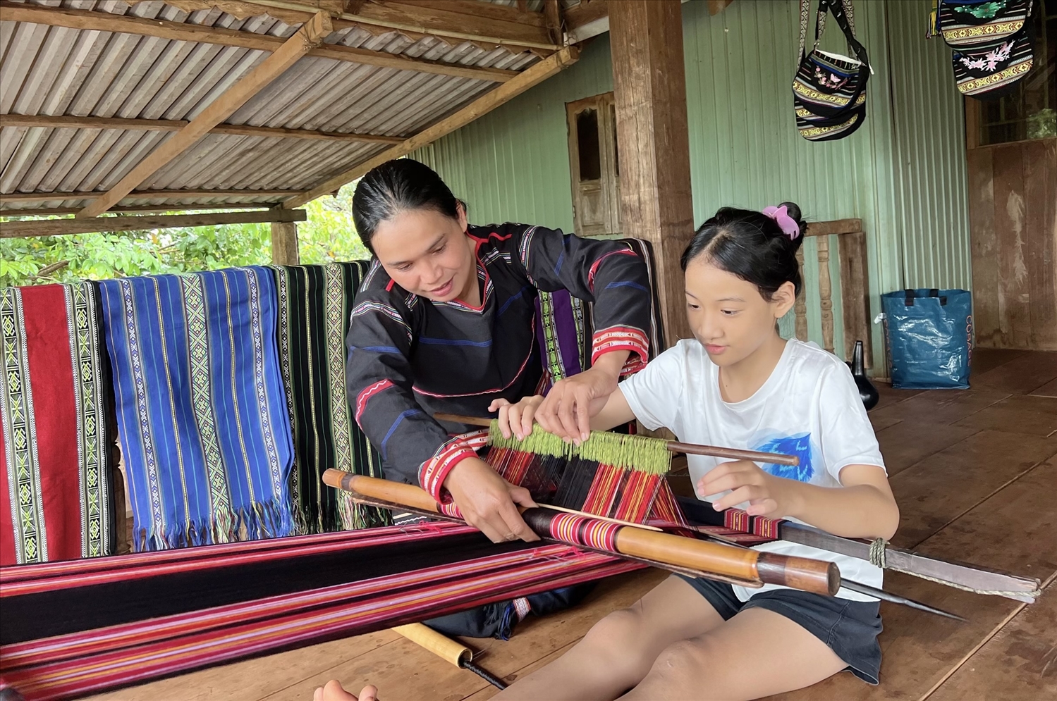 Nghệ nhân trong Tổ liên kết “đan lát, dệt thổ cẩm gắn với du lịch cộng đồng” (xã Ia Mơ Nông, huyện Chư Păh) hướng dẫn thế hệ trẻ cách dệt thổ cẩm truyền thống