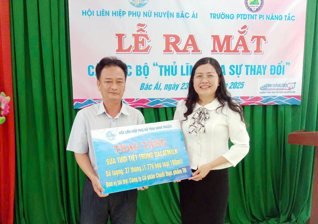 Bà Phan Thị Ngân Hạnh, Chủ tich Hội LHPN tỉnh trao bảng tượng trưng tặng 37 thùng sữa Dalatmilk cho học sinh Trường Phổ thông DTNT Pi Năng Tắc.