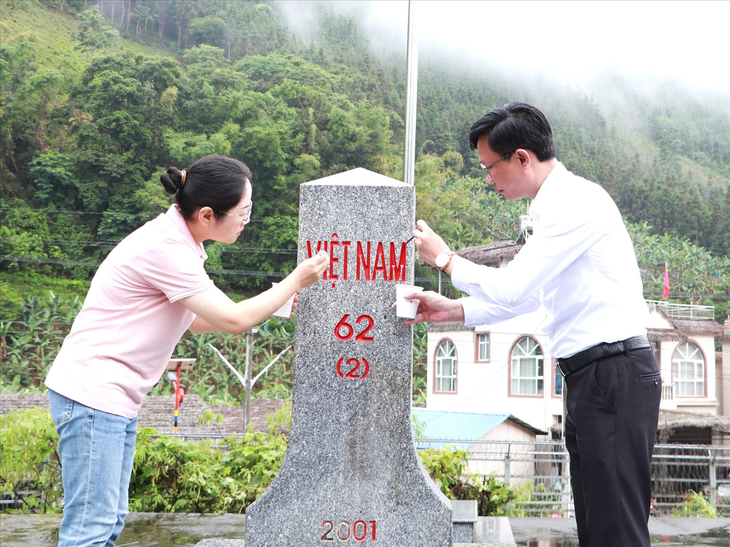 Đồng chí Kiều Hải Nam - Giám đốc Sở Ngoại vụ tỉnh Lai Châu và đồng chí Lưu Phương - Phó Ban Ngoại vụ Chính quyền nhân dân châu Hồng Hà tô sơn tại mốc giới số 62(2).
