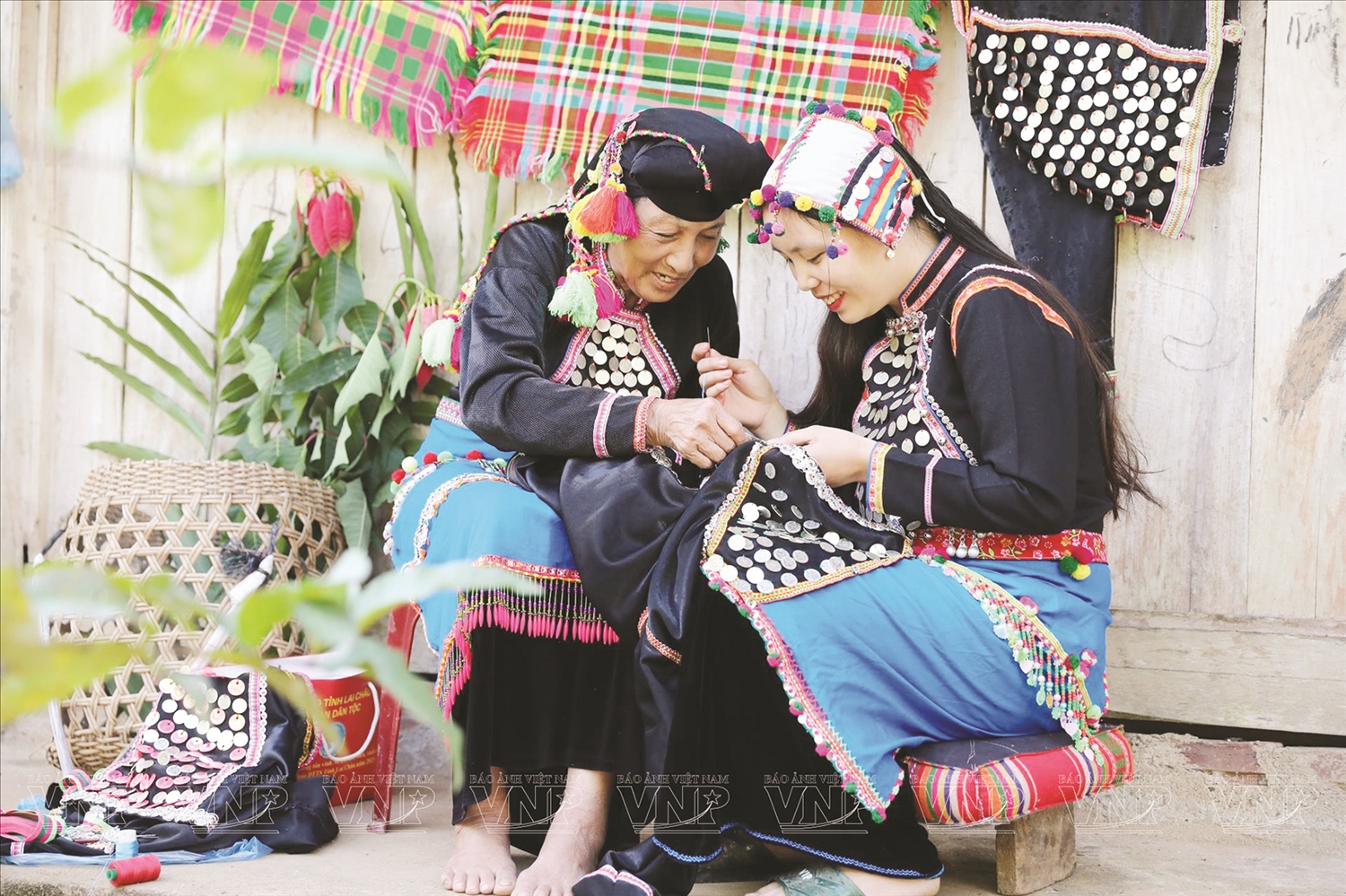 Bà Hù Cố Xuân, dân tộc Si La, nghệ nhân văn hóa - Người có uy tín ở bản Seo Hai, xã Can Hồ, huyện Mường Tè, tỉnh Lai Châu hướng dẫn cho lớp trẻ bảo tồn trang phục truyền thống dân tộc. Ảnh TL