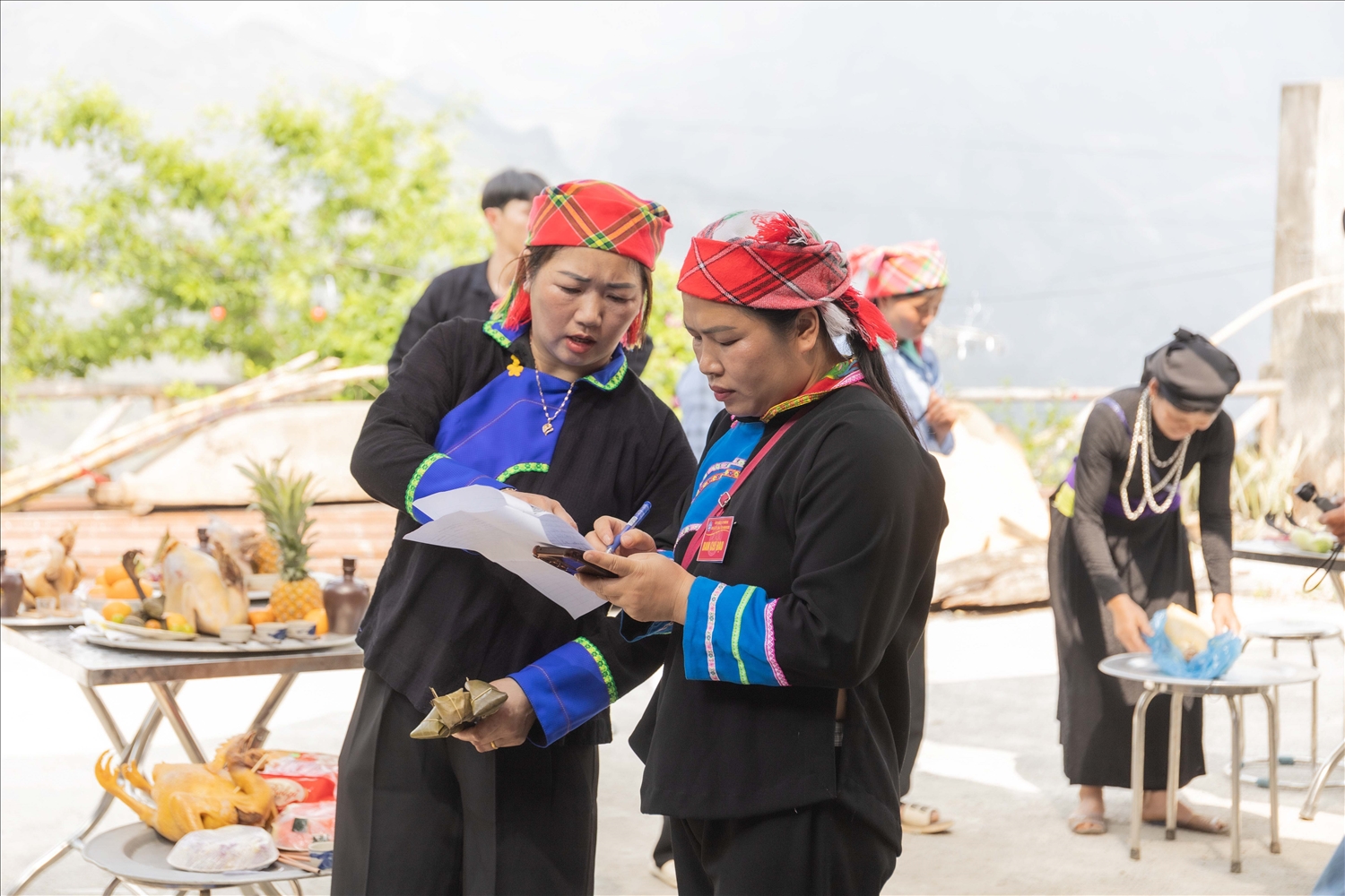 Chị Lương Thị Mòn (bên trái bức ảnh), Trưởng thôn, Người có uy tín của thôn Khâu Vai, xã Khâu Vai, huyện Mèo Vạc trong quá trình chuẩn bị cho Lễ hội Chợ phong lưu Khâu Vai năm 2025