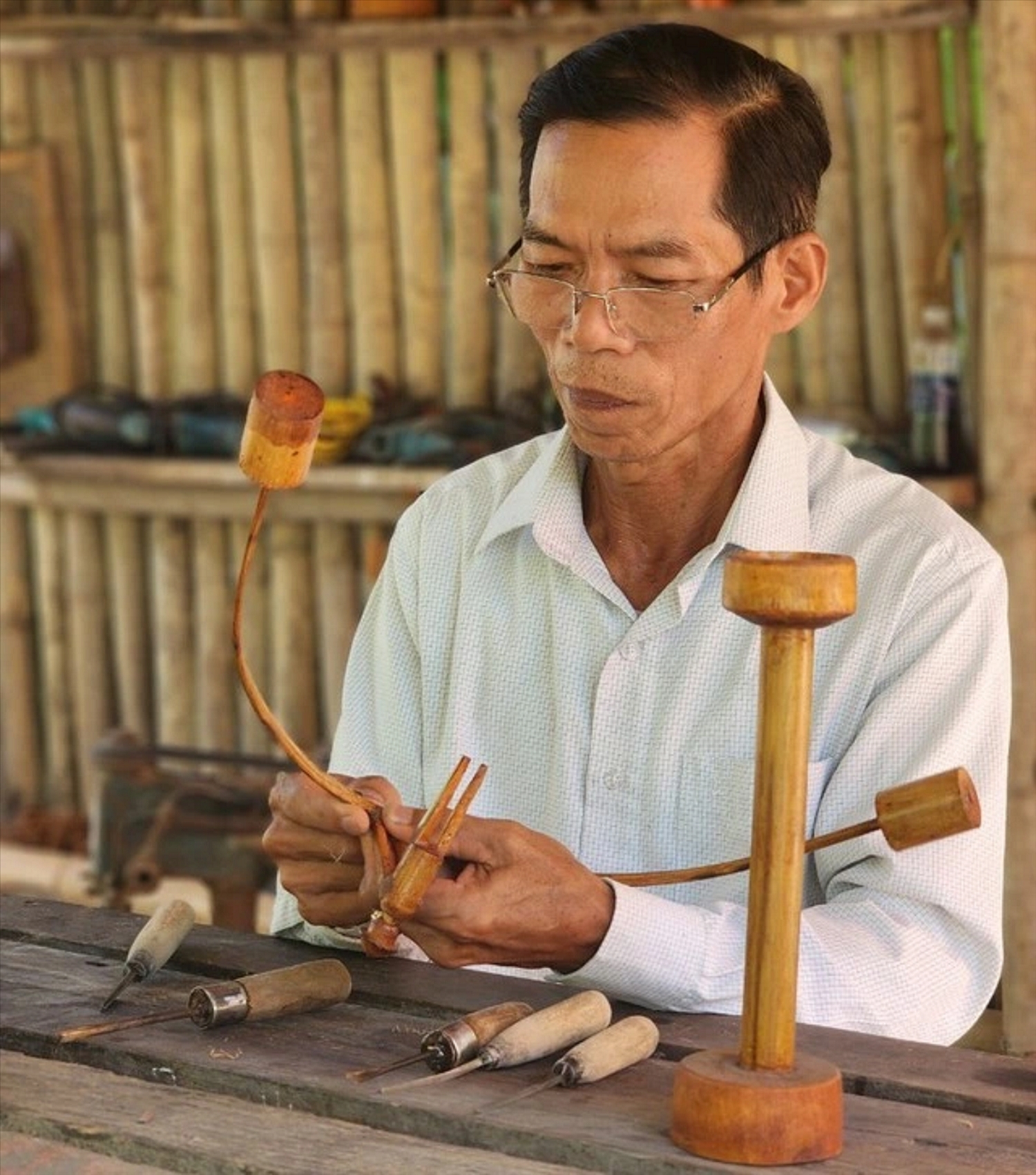 Nghệ nhân Trần Văn Hùng đang ""thổi hồn" cho tre trúc.