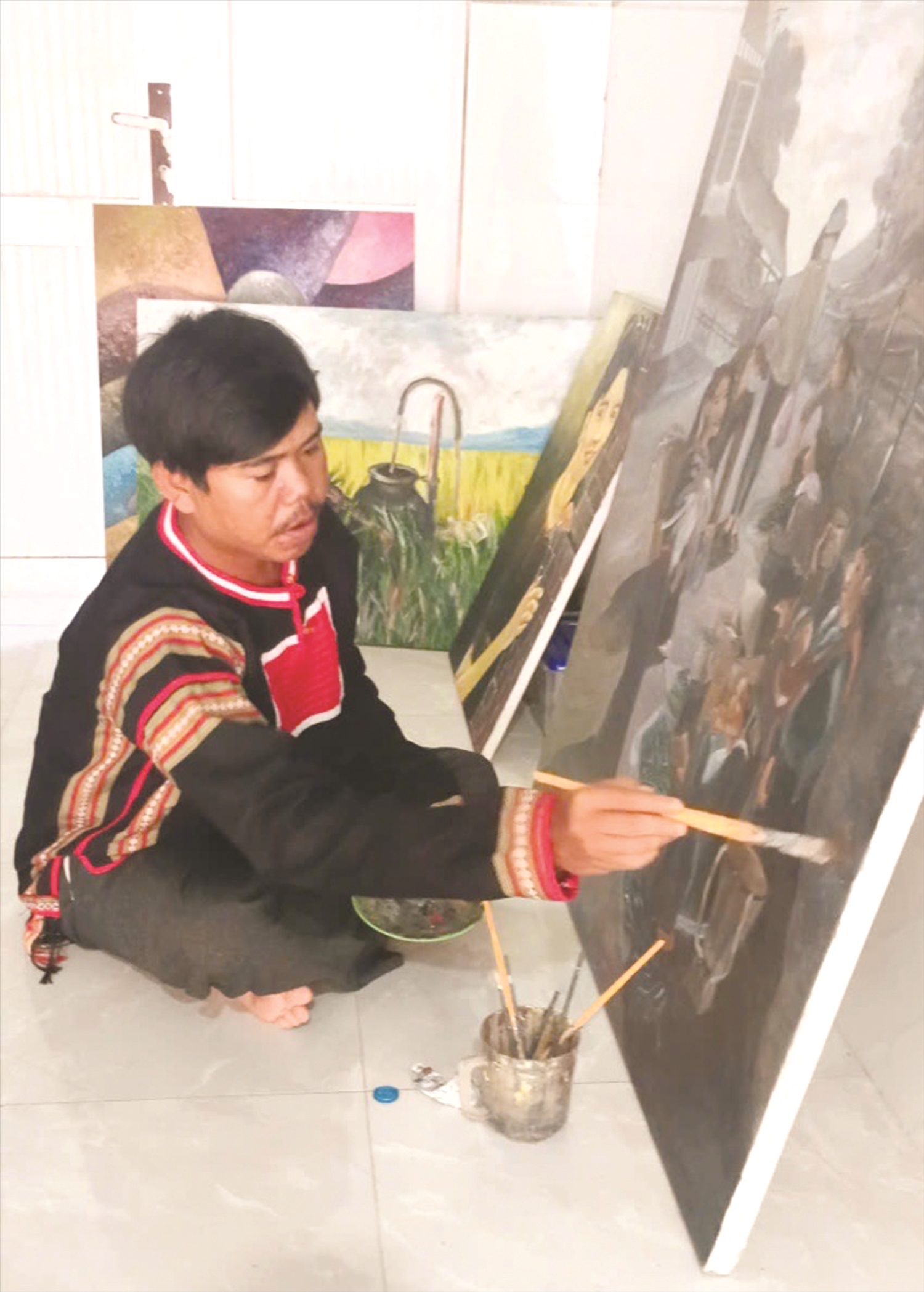 Họa sĩ KPă Tý đang hoàn thiện tác phẩm để tham gia triển lãm khu vực Nam miền Trung Tây Nguyên năm 2025. Ảnh: H.H THẾ.