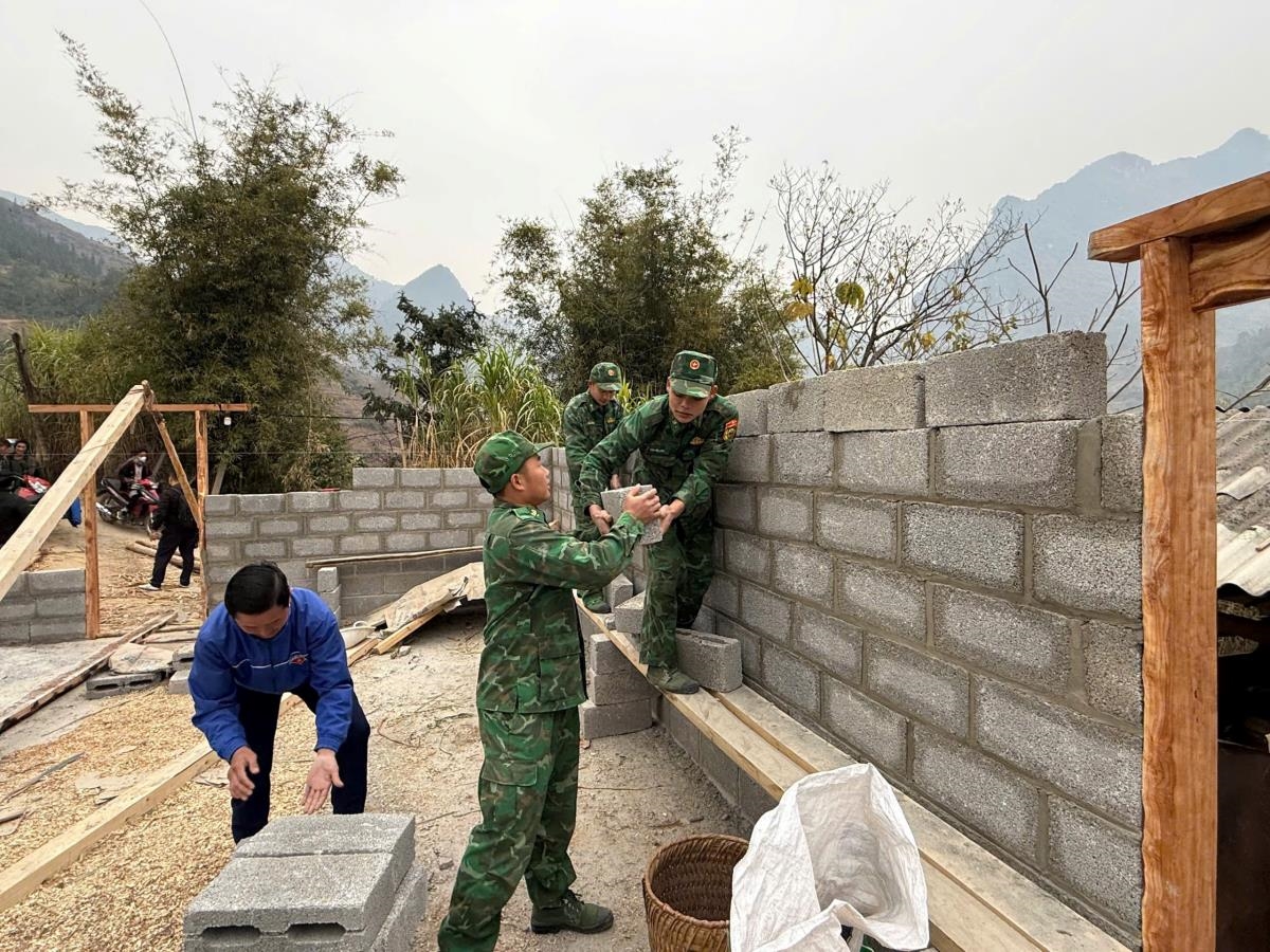 Cán bộ Đồn Biên phòng Sơn Vĩ, BĐBP Hà Giang phối hợp với các lực lượng giúp người dân xóa nhà tạm, xây dựng nhà khang trang. Ảnh: Quang Lập
