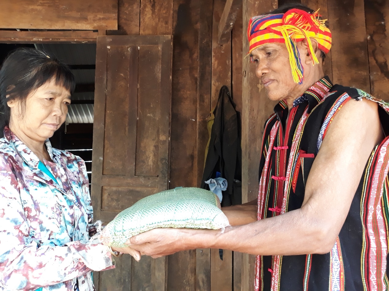 Ông Điểu Va, dân tộc S'tiêng, Người có uy tín ở thôn 2, xã Thống Nhất, huyện Bù Đăng, tỉnh Bình Phước tặng gạo cho bà con đồng bào khó khăn trong xóm (Ảnh minh họa).