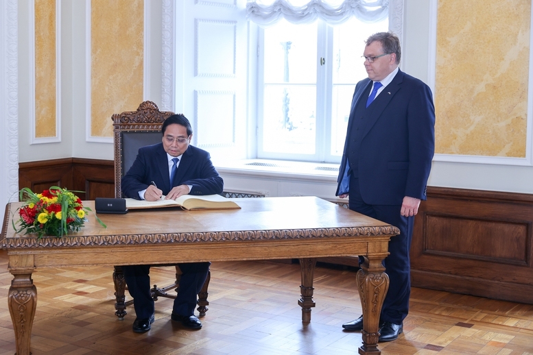 Thủ tướng ghi lưu bút tại trụ sở Quốc hội Estonia - Ảnh: VGP/Nhật Bắc