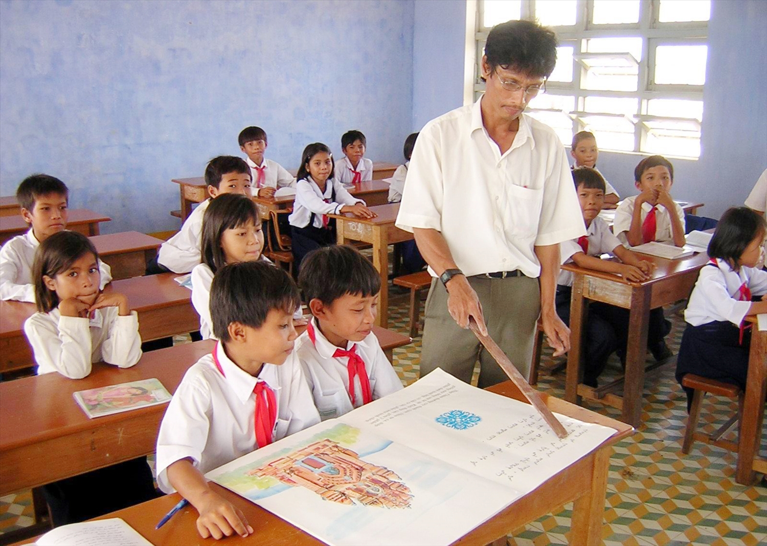 Học sinh tiểu học vùng đồng bào Chăm trên địa bàn tỉnh Ninh Thuận được học Chữ Chăm. Trong ảnh: Thầy giáo Dổng Bé hướng dẫn học sinh Trường TH Hiếu Lễ, xã Phước Hậu, huyện Ninh Phước học chữ Chăm. 