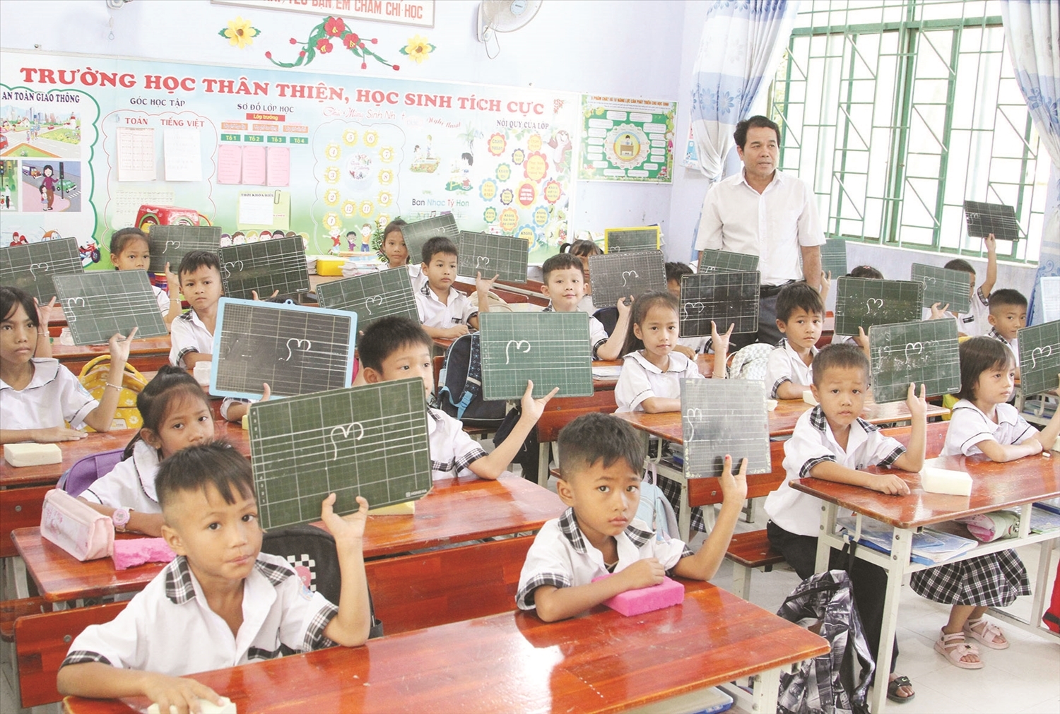 Thầy giáo Đàng Năng Mạng rèn kỹ năng tập viết chữ Chăm cho học sinh Trường Tiểu học Mỹ Nghiệp - Chung Mỹ, huyện Ninh Phước, tỉnh Ninh Thuận.