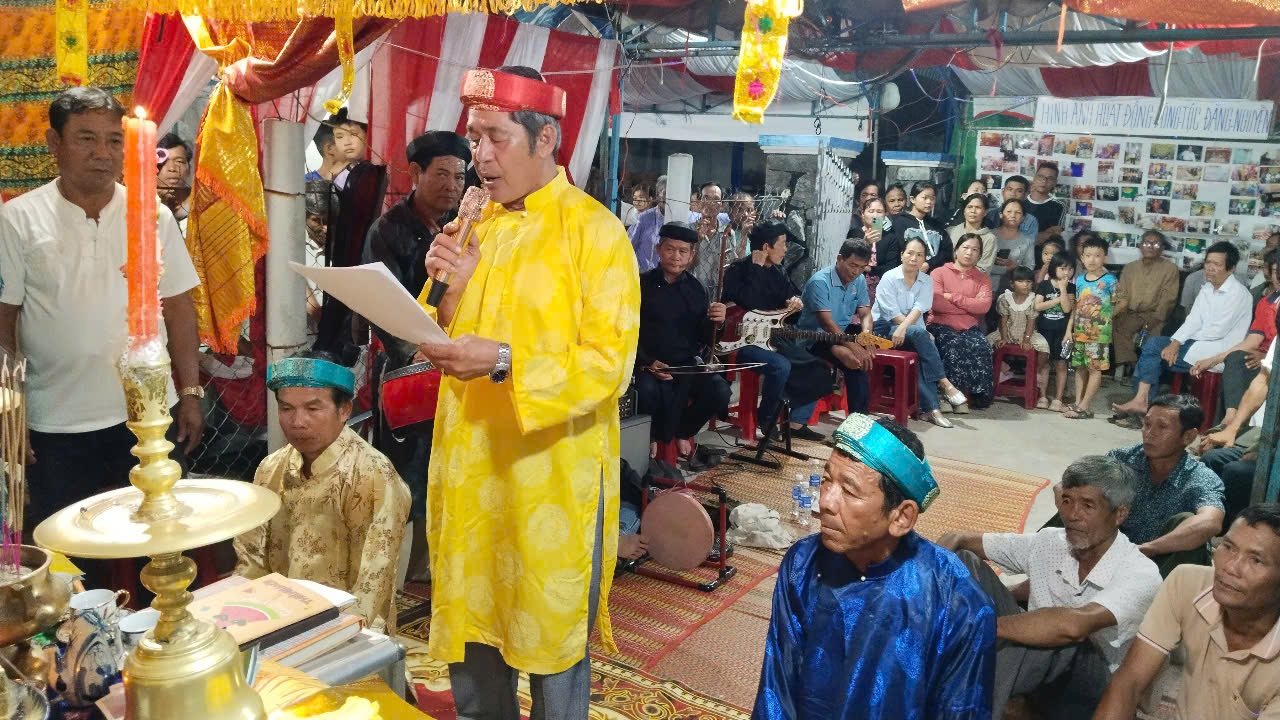 Chủ lễ đang đọc tên của người chết trong tộc chuyển thành họ Nguyễn để nhập gia phả.