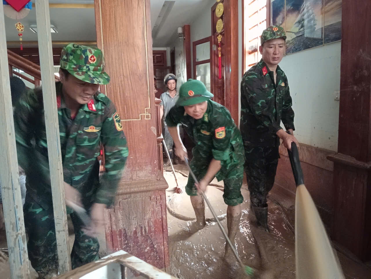 Cán bộ, chiến sĩ hỗ trợ người dân dọn dẹp nhà cửa
