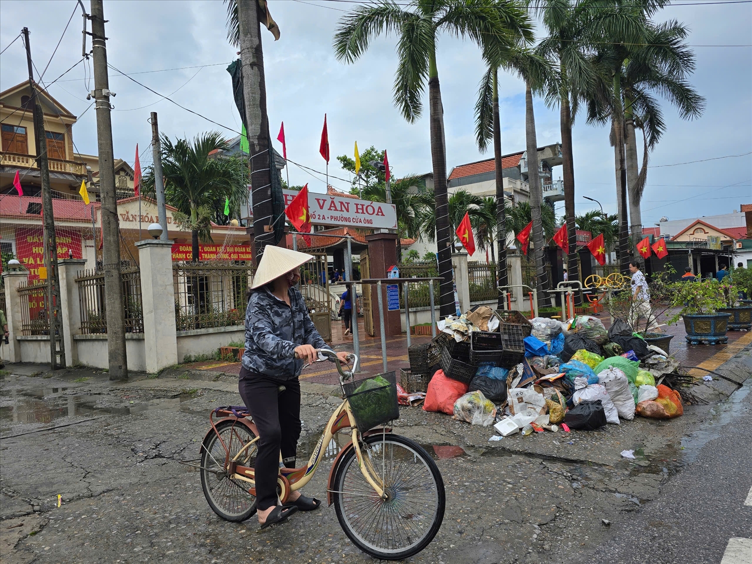 Chị Nguyễn Thị Lan Anh, trú tại phường Cửa Ông, than thở: “Gần một tuần rồi không ai đến thu rác. Rác đầy từ ngoài đường, đến trước cửa nhà văn hóa, sát bệnh viện… Nếu cứ tiếp diễn thế này, vài ngày nữa chắc rác cao đến đầu người.” (Ảnh: Mỹ Dung)
