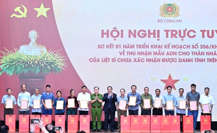 Thủ tướng Chính phủ Phạm Minh Chính trao Thông báo kết quả giám định ADN hài cốt liệt sĩ cho đại diện thân nhân các gia đình liệt sĩ. (Ảnh: Trần Hải) 