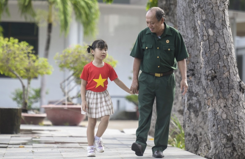 Thượng sĩ Nguyễn Chí Tường cùng con một nhân viên Vinamilk tại Trung tâm Điều dưỡng Thương binh và Người có công Long Đất (Ảnh: Thanh Bình).
