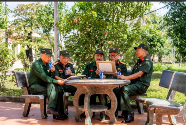 Các bác cựu chiến binh chăm chú đọc những dòng chữ nhỏ, được các em gửi kèm trong mỗi bức tranh. (Ảnh: Duy Cường)