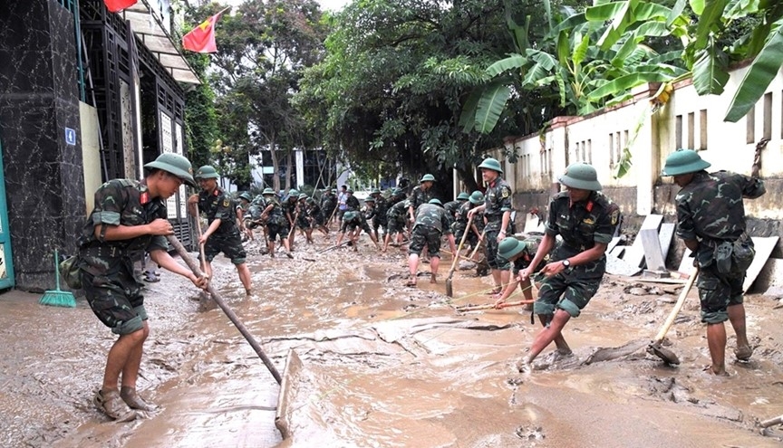 Cán bộ, chiến sĩ Trung đoàn 335, Sư đoàn 324 tổ chức dọn dẹp đường giao thông khu phố 2, xã Con Cuông.(ảnh Quỳnh Trâm)