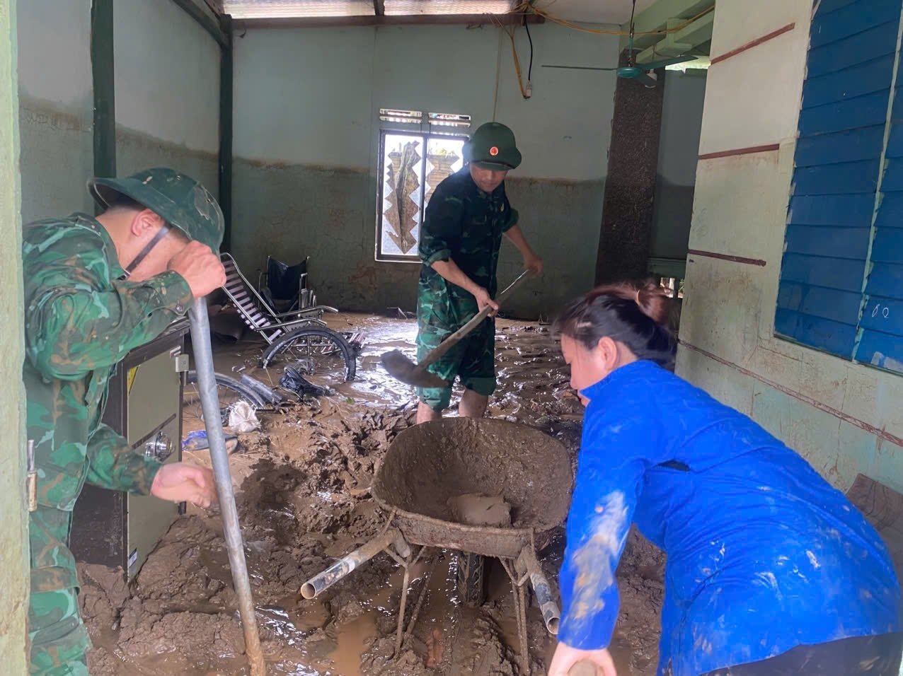 Lực lượng vũ trang giúp các hộ dân giải phóng bùn đất ra khỏi nhà.(ảnh Phạm Tiến)