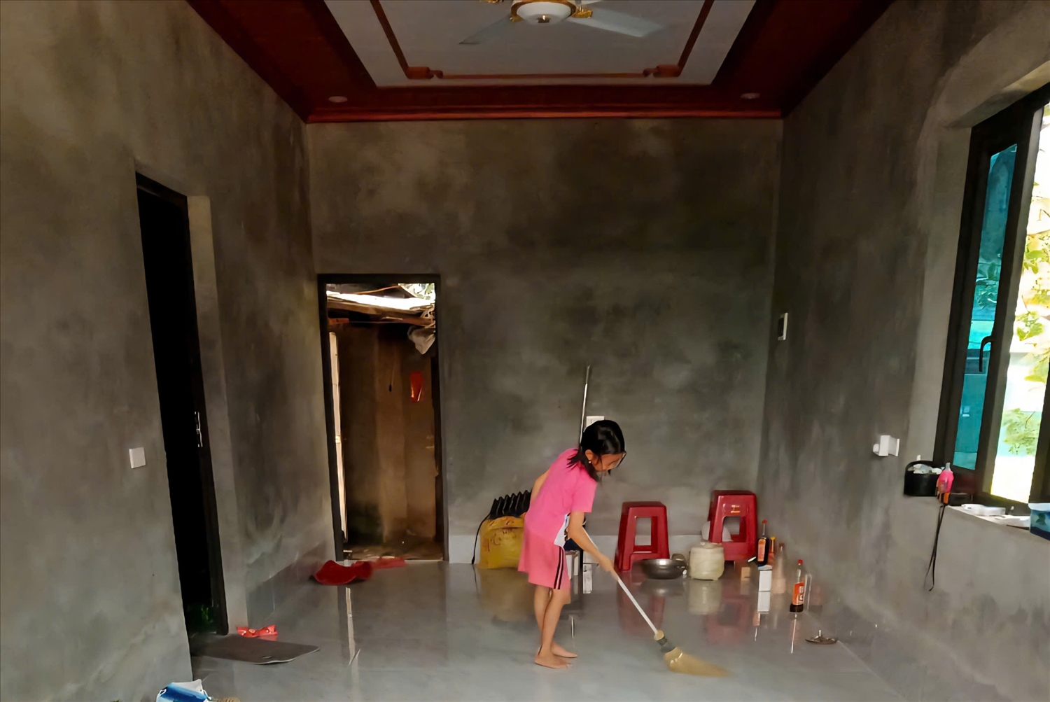 Con gái anh Lỷ Tắc Quay ở thôn Nà Nhái (xã Bình Liêu) đang quét dọn trong căn nhà mới của gia đình (Ảnh: Mỹ Dung)