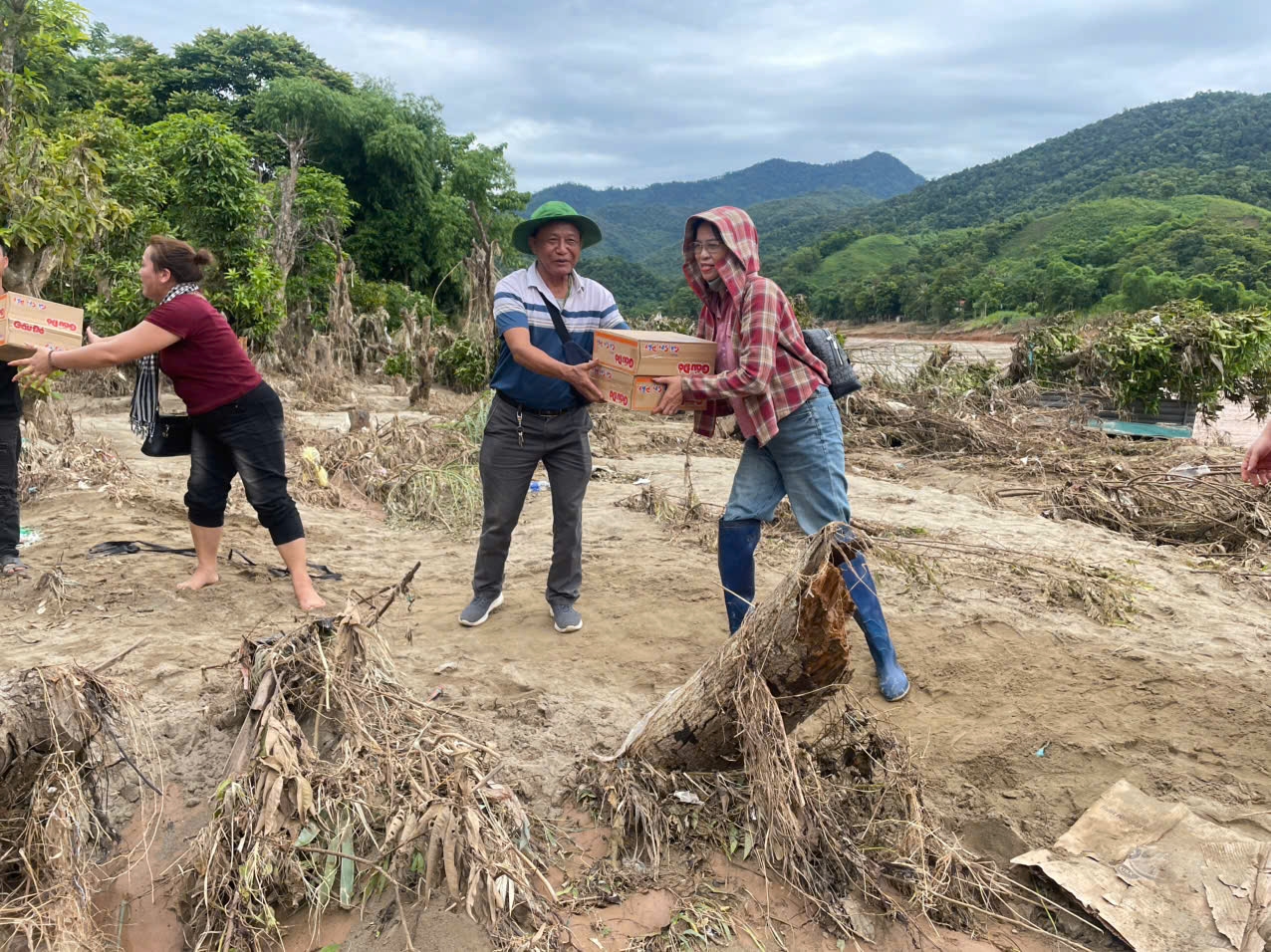 Thành viên đoàn thiện nguyện Đại Minh vận chuyển nhu yếu phẩm xuống thuyền để vượt sông về với bà con ở bản Lau (Ảnh: Phạm Tiến)