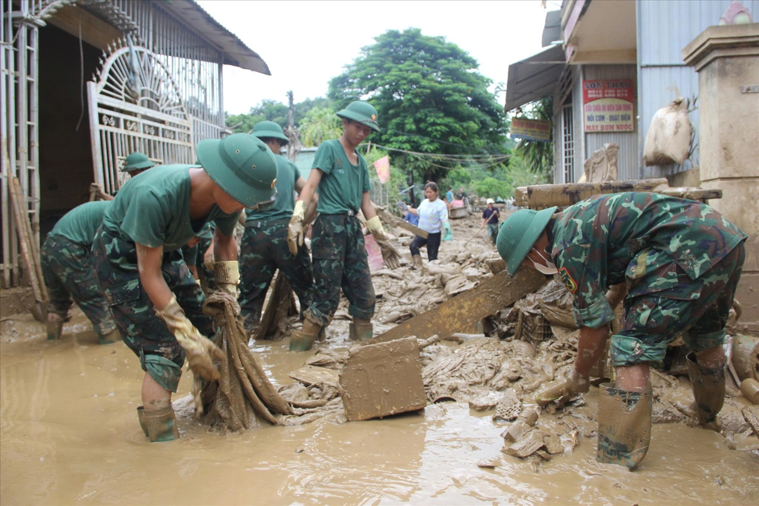 Cán bộ chiến sĩ thuộc Tiểu đoàn 1, Sư đoàn bộ binh 324, Quân Khu 4 tham gia dọn bùn đất sau lũ cùng bà con khối Hòa Đông, xã Tương Dương - Ảnh: Thanh Hải