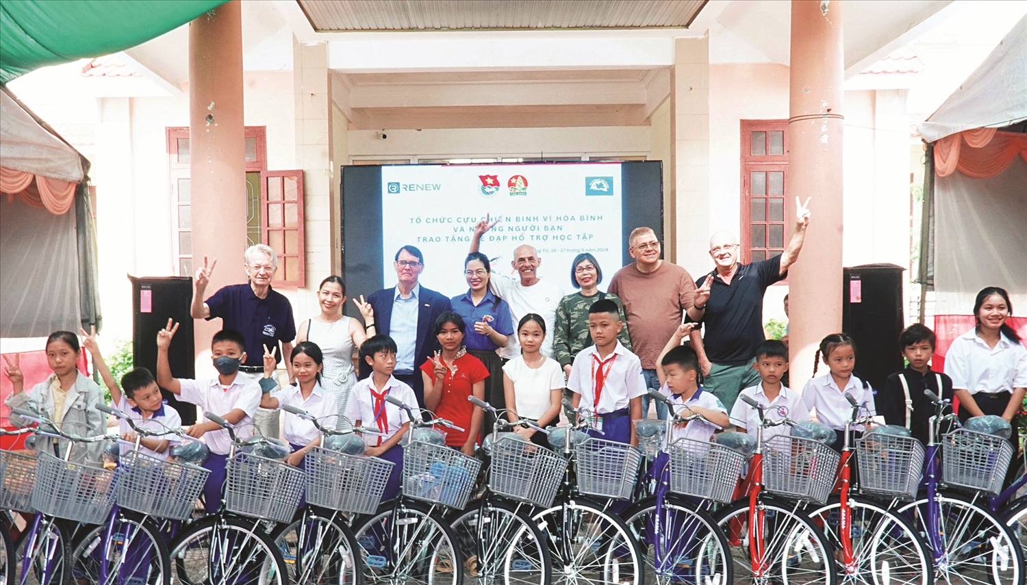 Cựu chiến binh Mỹ và đại biểu chụp ảnh lưu niệm với học sinh huyện miền núi Hướng Hóa (tên địa danh cũ trước sáp nhập), tỉnh Quảng Trị trong buổi Lễ trao xe đạp. Ảnh minh họa