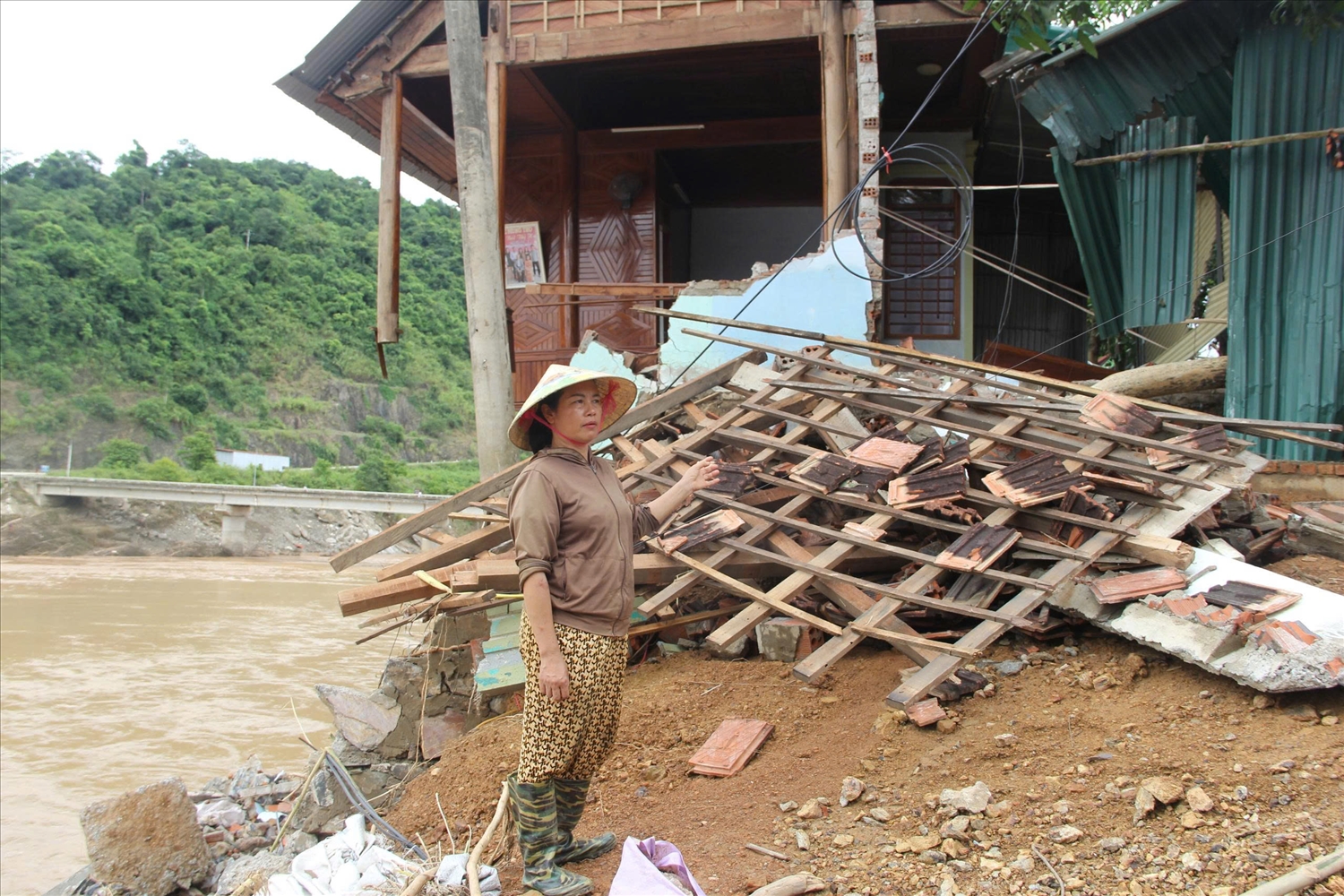 Chị Trịnh Thị Nhuân – người dân bản Cửa Rào 2, xã Tương Dương bên căn nhà chỉ còn là đống đổ nát - Ảnh: Thanh Hải