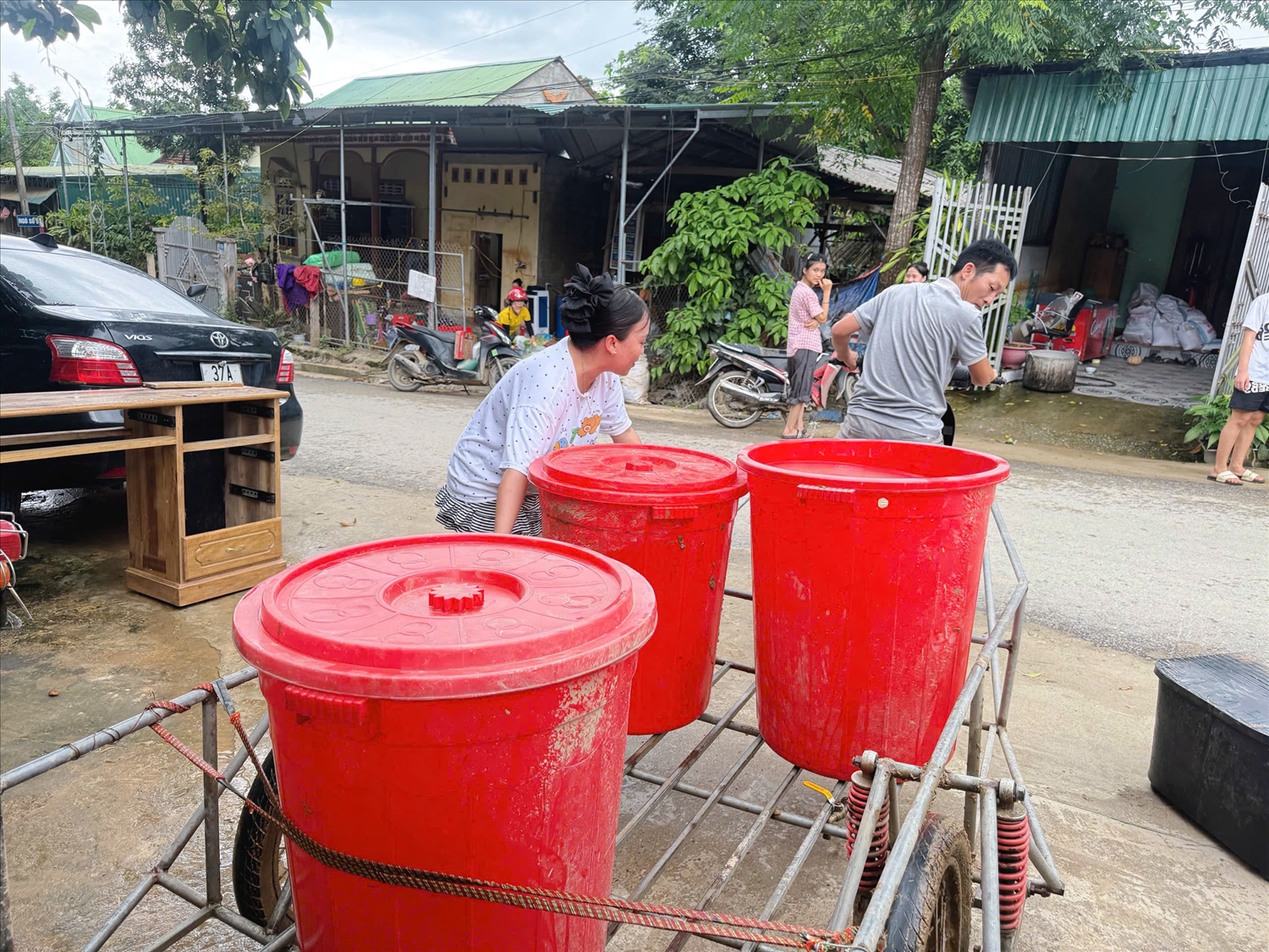 Vợ chồng thầy Trương Xuân Bình và cô Nguyễn Ngọc Trâm chở nước phục vụ các gia đình để vệ snh nhà cửa.