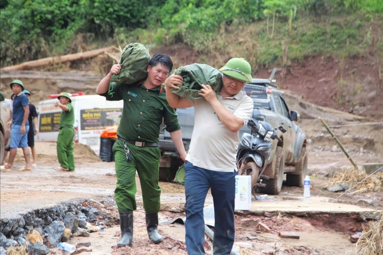 Ông Mạc Văn Nguyên, Bí thư Đảng ủy xã Nhôn Mai và ông Lô Tú Tài, Trưởng Công an xã vác từng bì gạo vượt đường rừng đến cho các hộ gia đình 