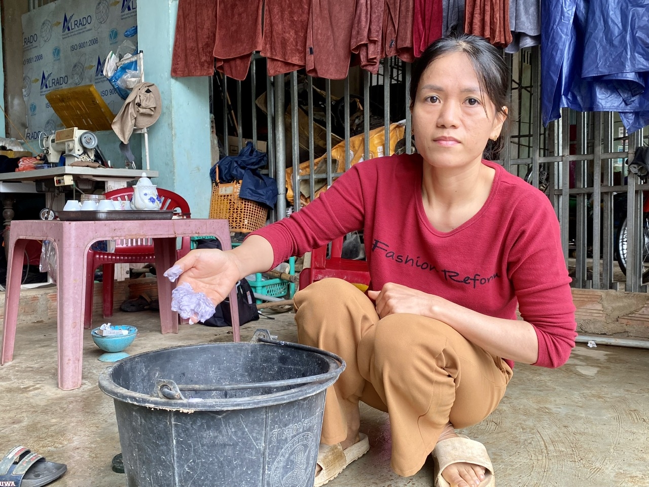 Phân NPK mà chị Trần Thị Thi nghi ngờ kém chất lượng được chị để trong xô nước hơn 1 tháng nay nhưng vẫn chưa tan hết. (Ảnh: Ngọc Chí)