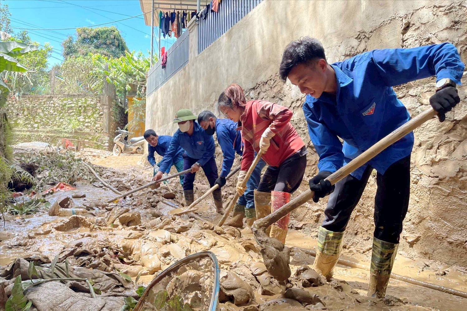 Màu áo xanh tình nguyện cùng bà con vùng lũ khắc phục hậu quả - Ảnh: Thanh Quỳnh